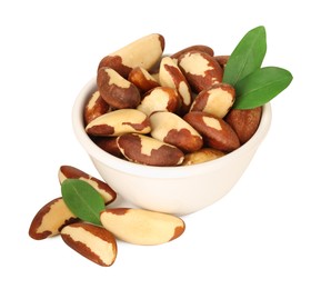 Photo of Tasty Brazil nuts in bowl and green leaves isolated on white