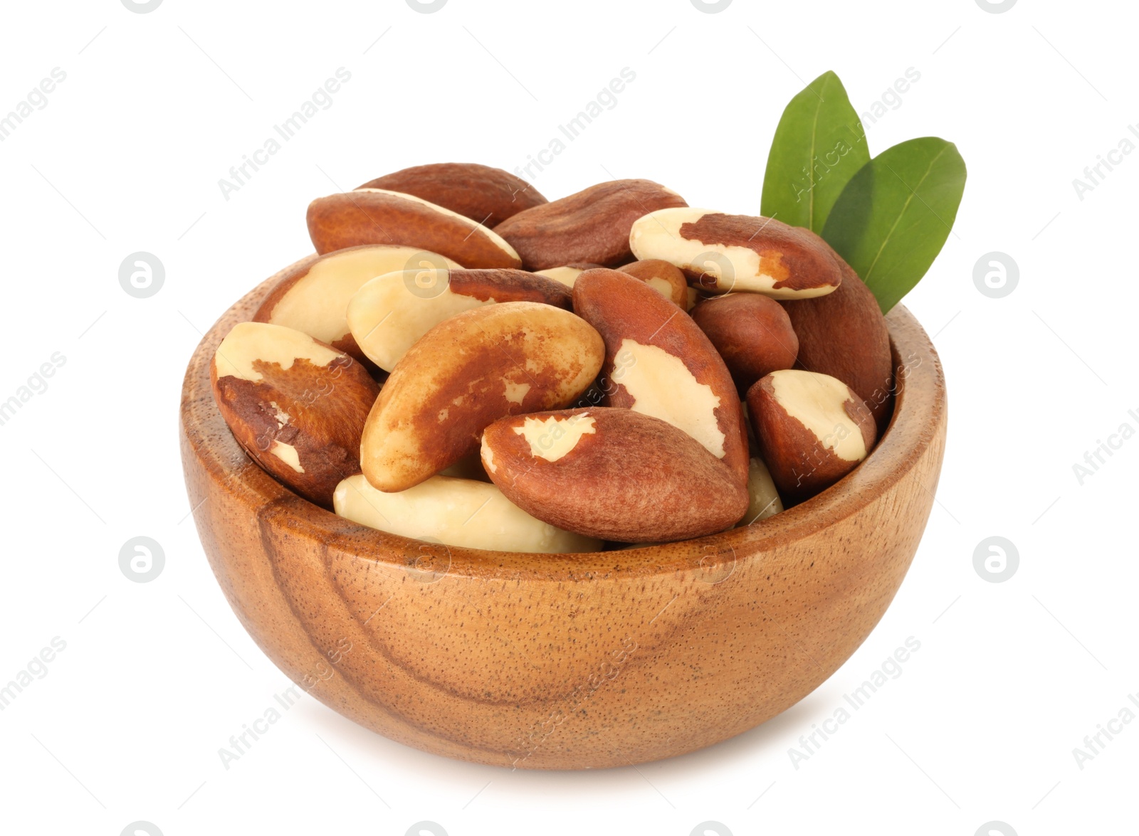 Photo of Tasty Brazil nuts and green leaves in bowl isolated on white