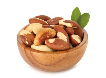 Photo of Tasty Brazil nuts and green leaves in bowl isolated on white