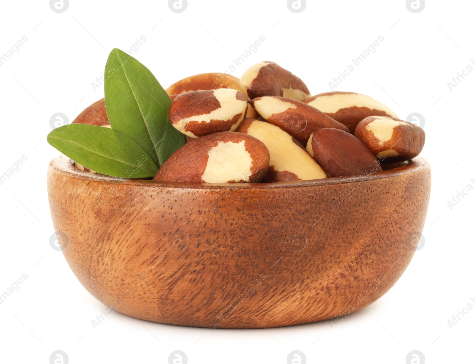 Photo of Tasty Brazil nuts and green leaves in bowl isolated on white