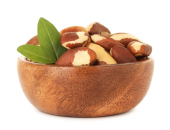 Photo of Tasty Brazil nuts and green leaves in bowl isolated on white