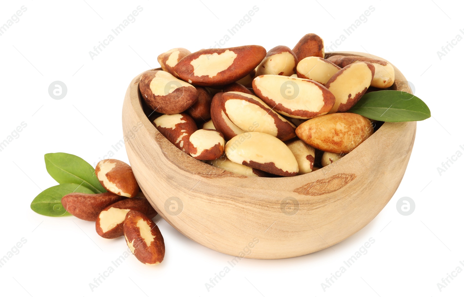 Photo of Tasty Brazil nuts and green leaves in bowl isolated on white