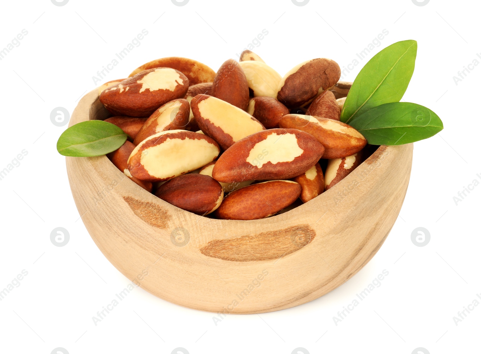 Photo of Tasty Brazil nuts and green leaves in bowl isolated on white