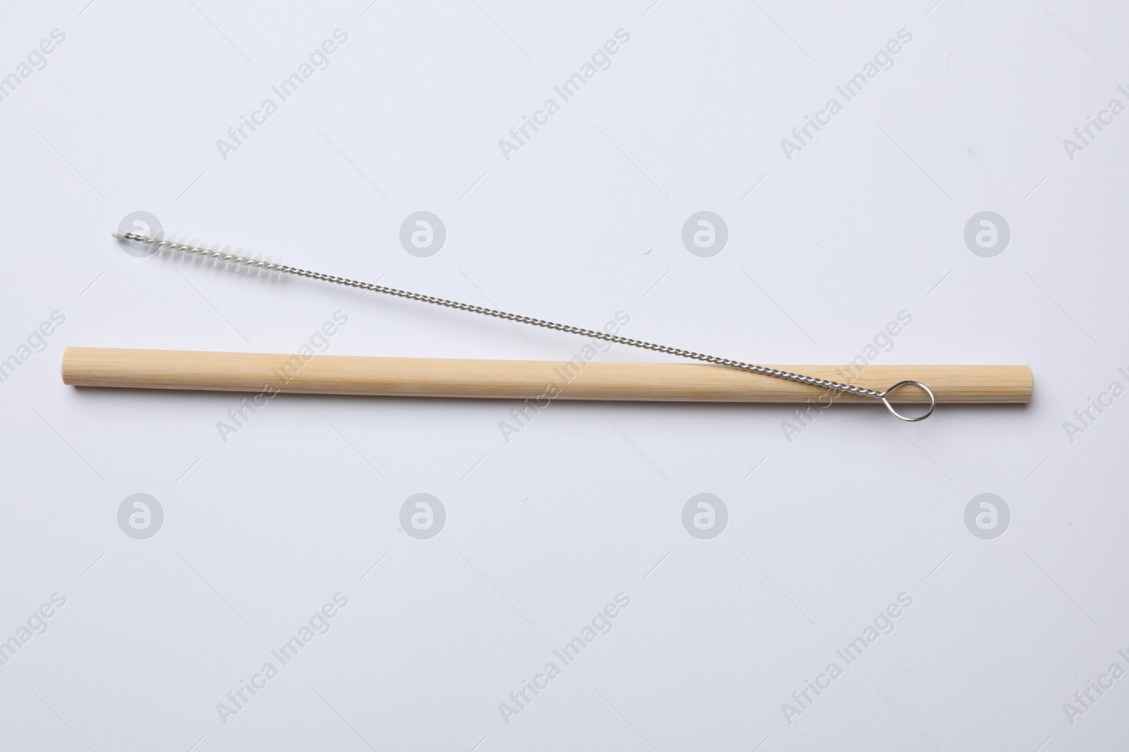 Photo of Bamboo drinking straw and cleaning brush on white background, top view