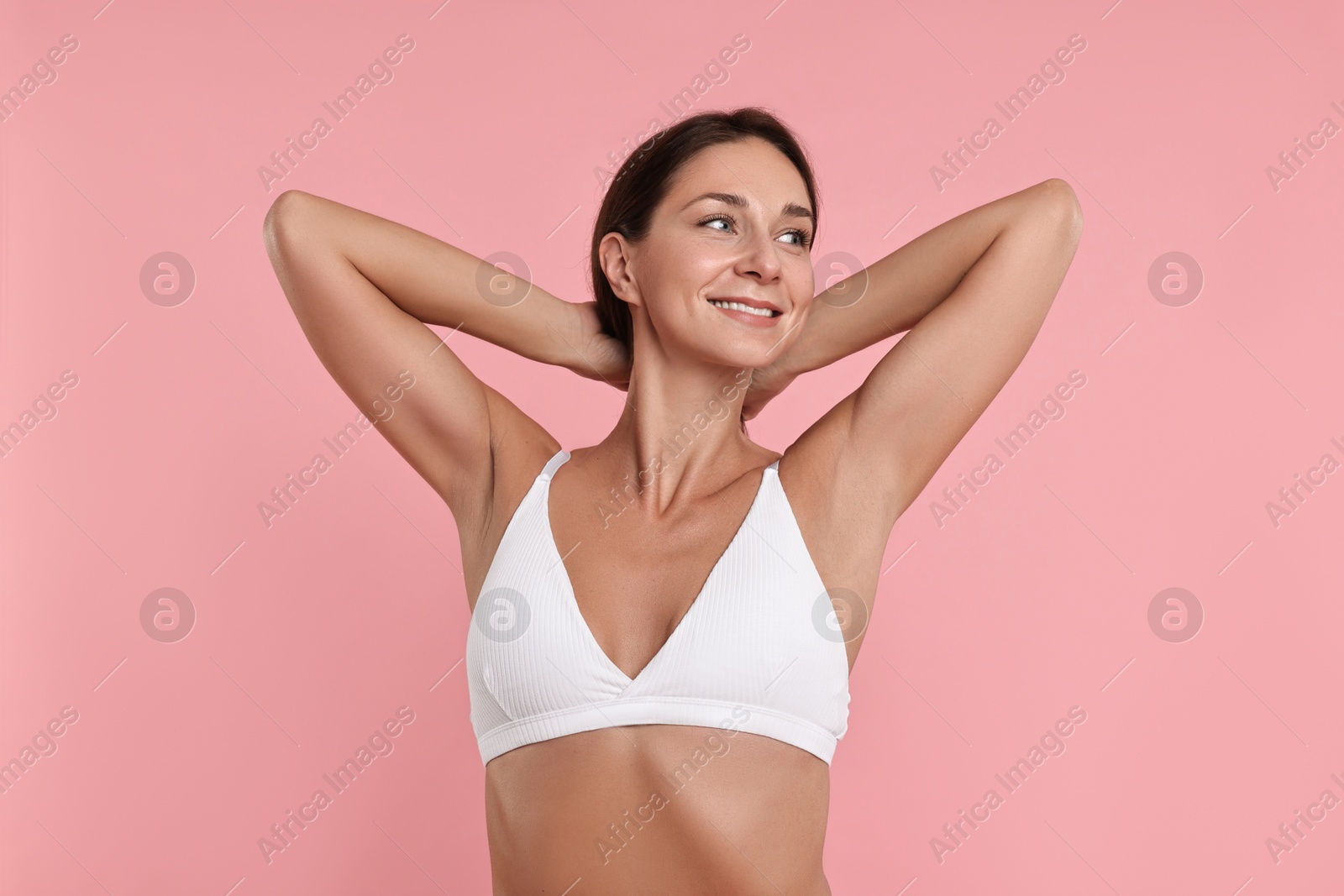 Photo of Smiling woman with perfect skin on pink background. Body care