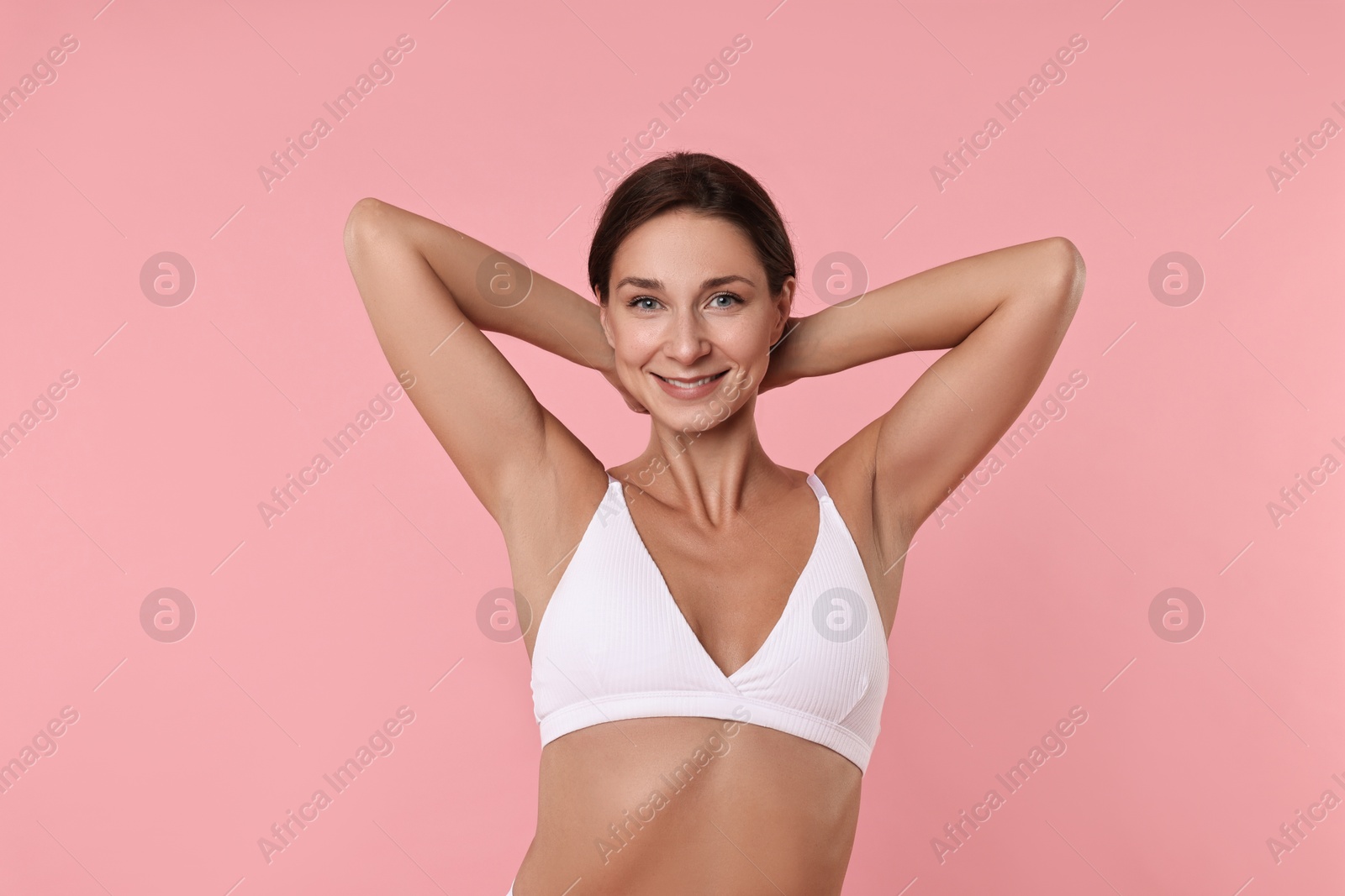 Photo of Smiling woman with perfect skin on pink background. Body care