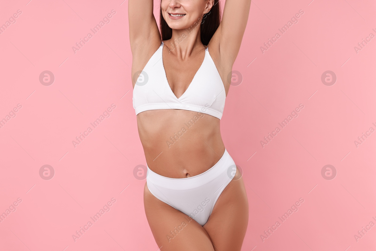 Photo of Smiling woman with perfect skin on pink background, closeup. Body care