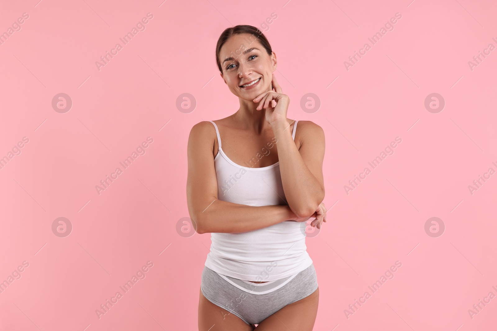 Photo of Smiling woman with perfect skin on pink background. Body care