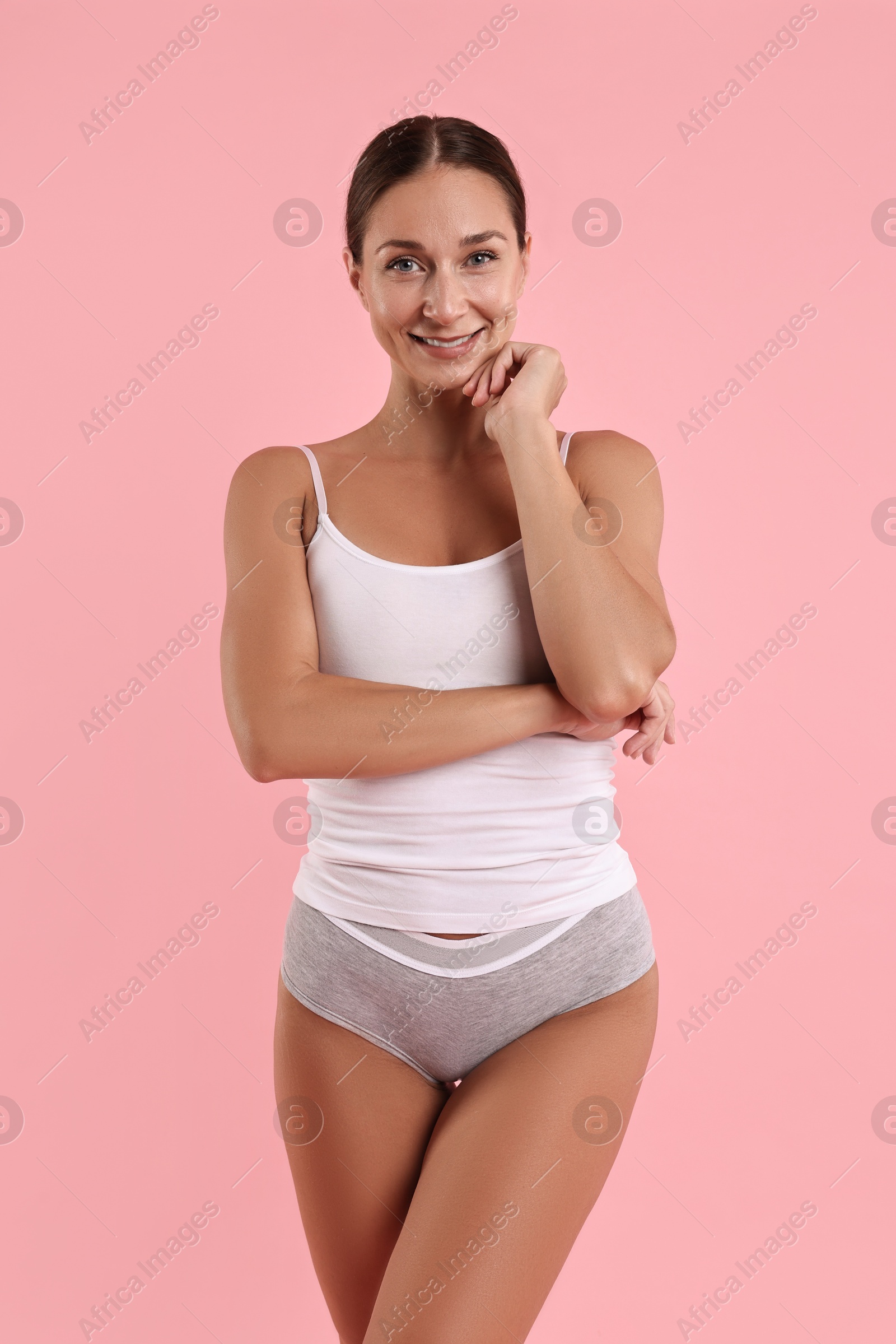 Photo of Smiling woman with perfect skin on pink background. Body care