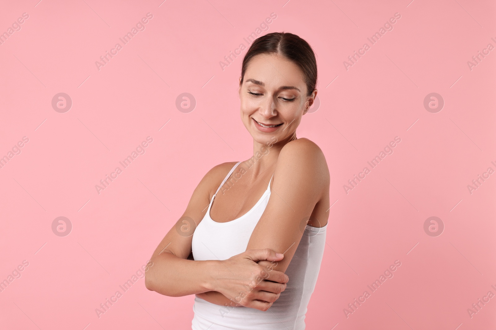 Photo of Smiling woman with perfect skin on pink background. Body care