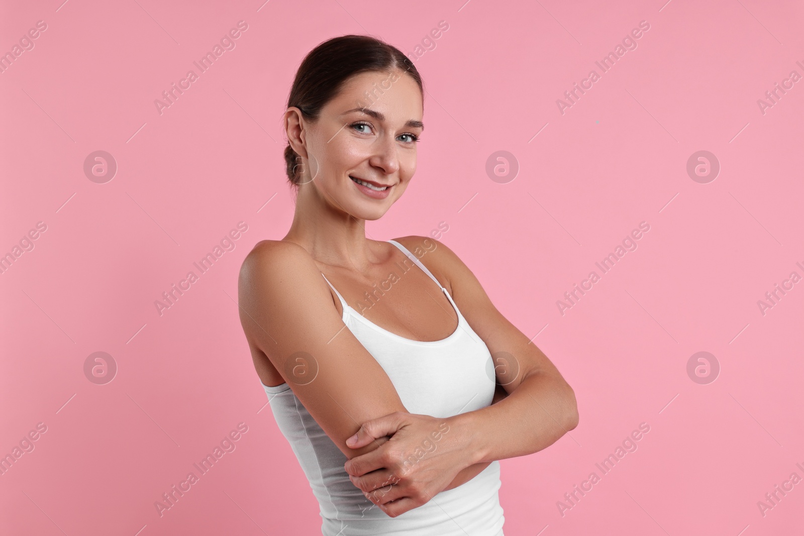 Photo of Smiling woman with perfect skin on pink background. Body care