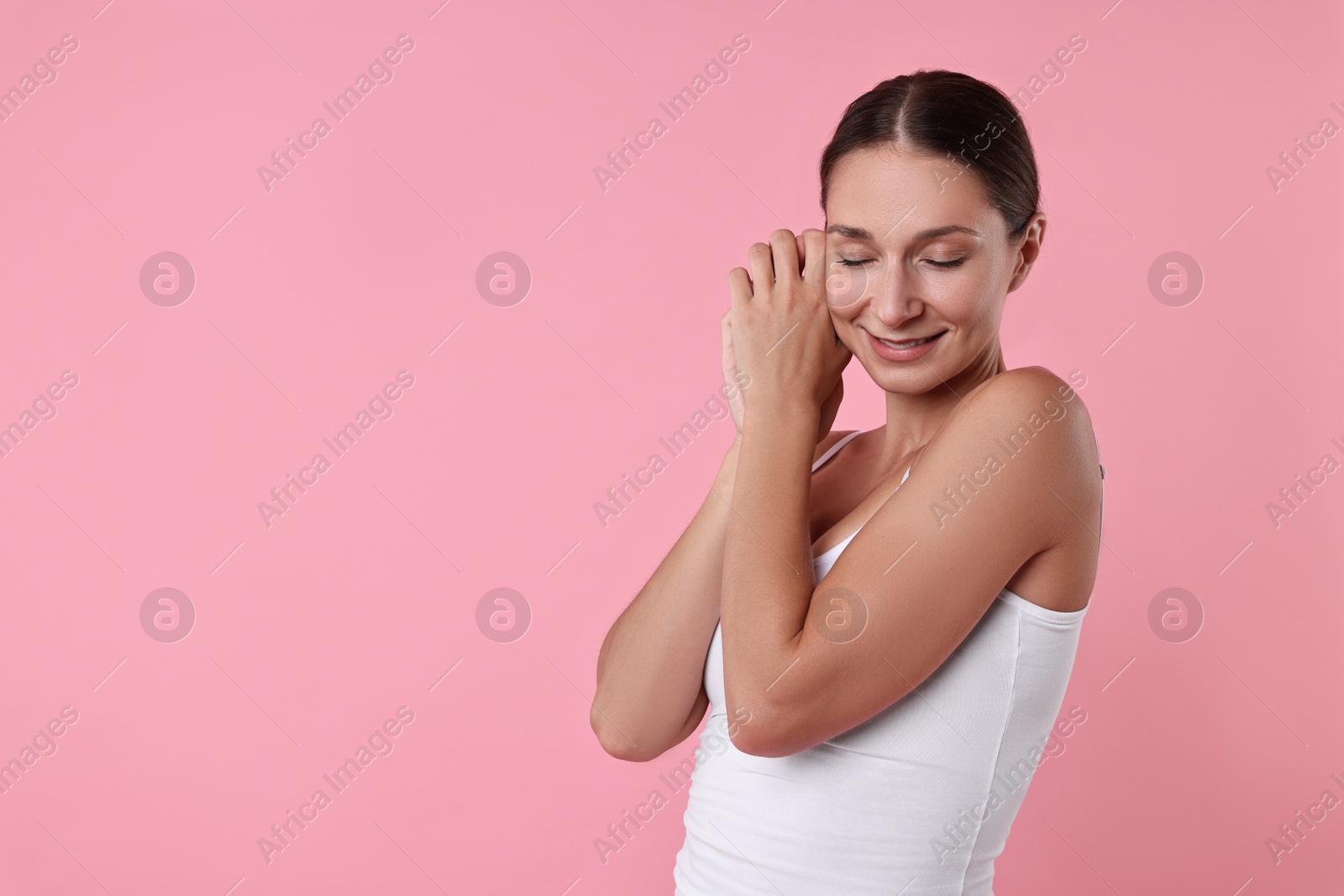 Photo of Smiling woman with perfect skin on pink background, space for text. Body care