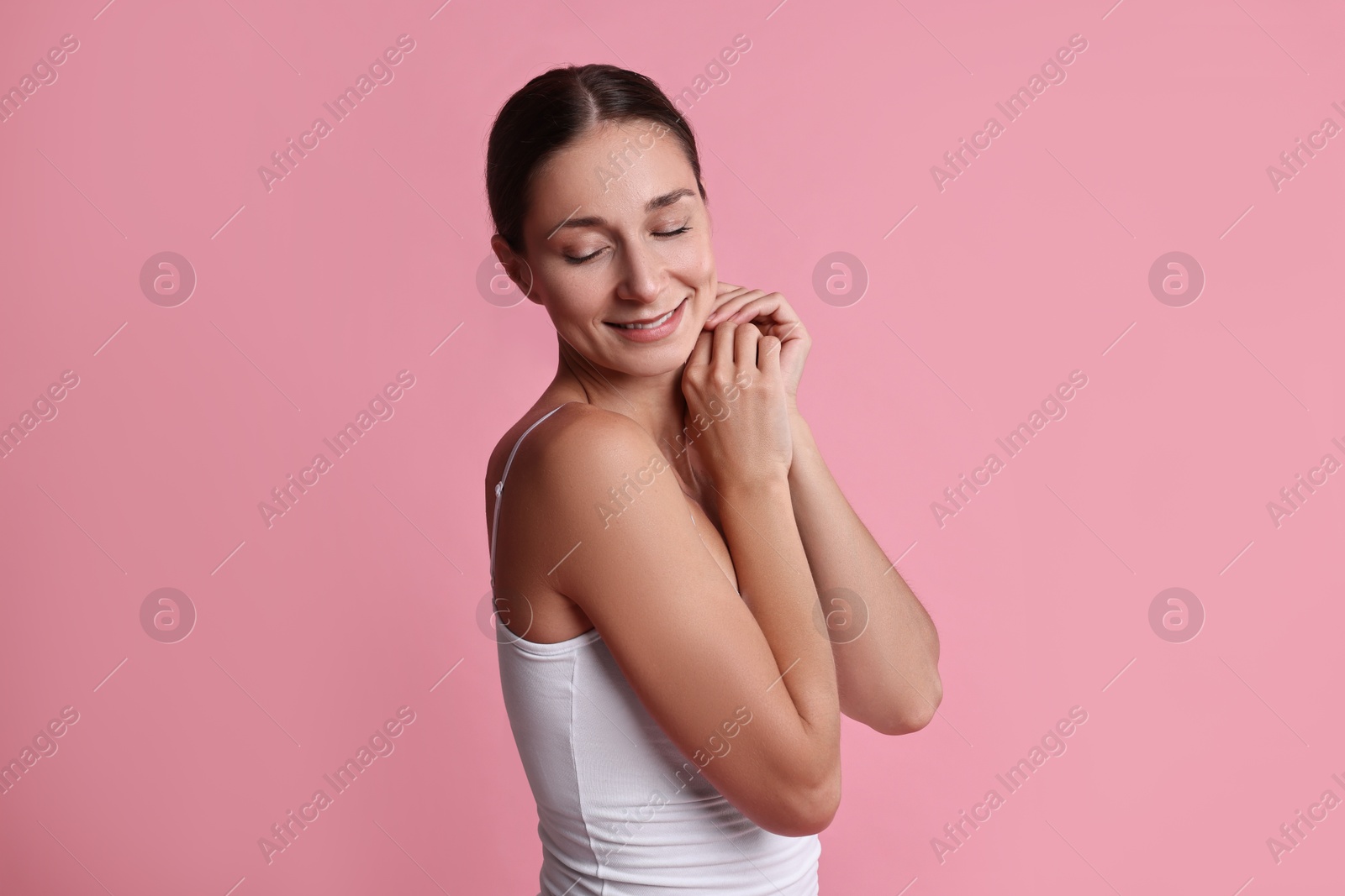 Photo of Smiling woman with perfect skin on pink background. Body care