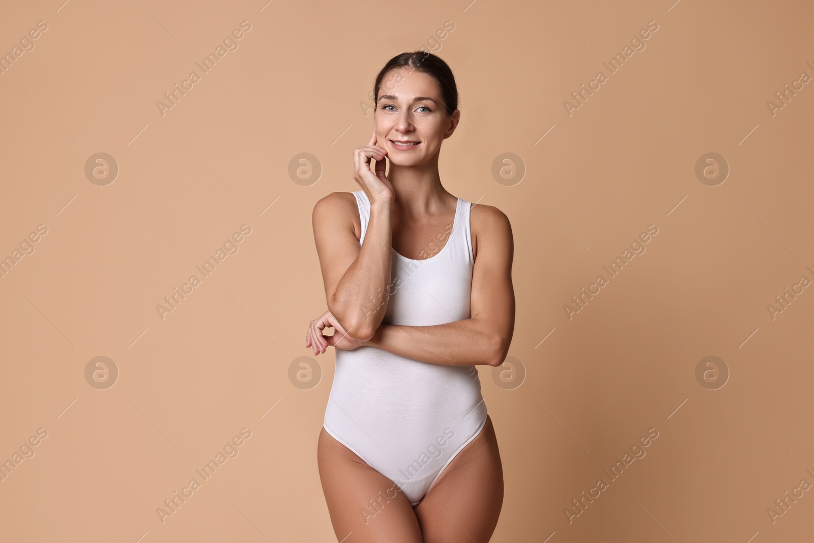 Photo of Smiling woman with perfect skin on beige background. Body care