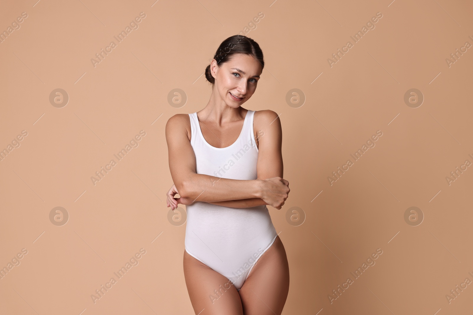 Photo of Smiling woman with perfect skin on beige background. Body care