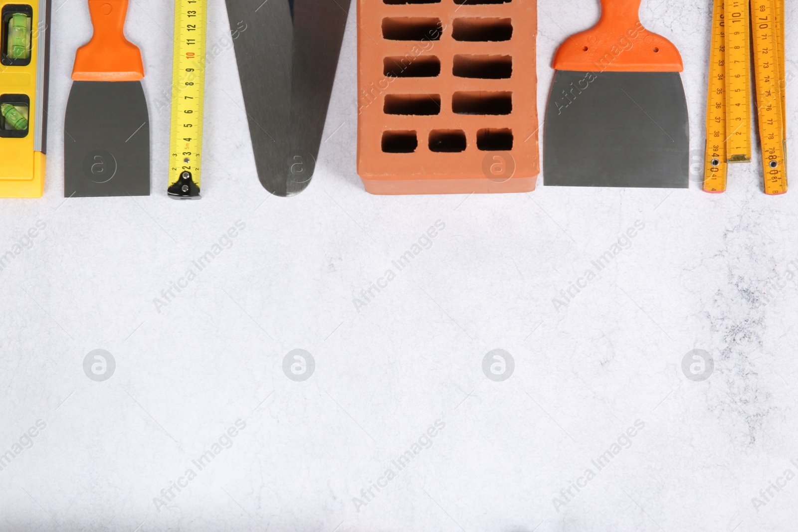 Photo of Many different construction tools and building materials on light textured table, flat lay. Space for text