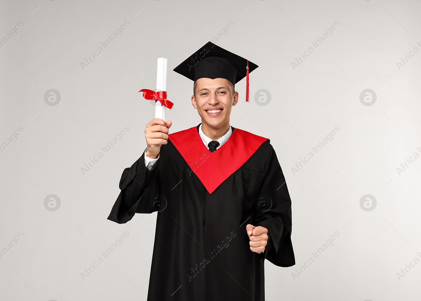 Photo of Happy student with diploma after graduation on light grey background. Space for text