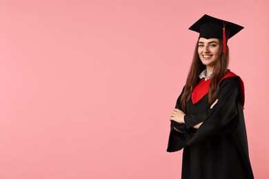 Photo of Happy student with crossed arms after graduation on pink background. Space for text