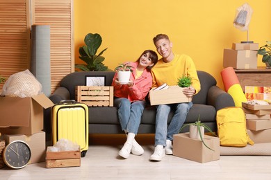 Happy couple with different stuff in new apartment. Housewarming party