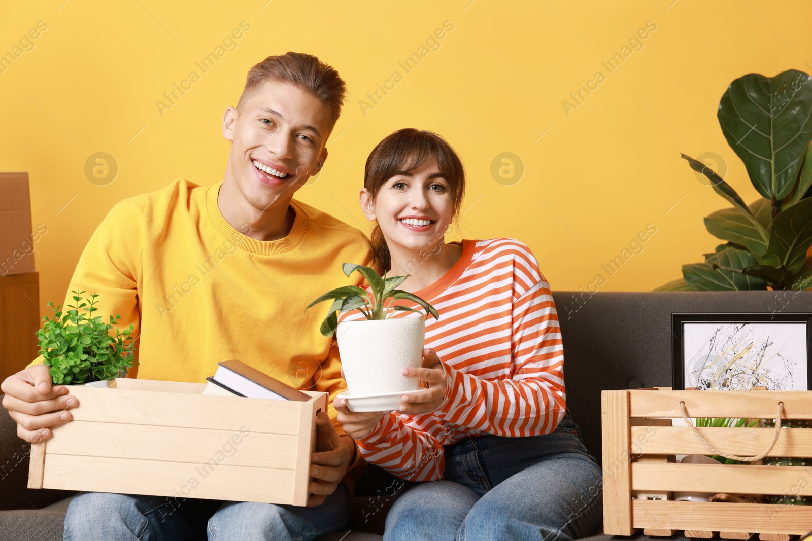 Photo of Happy couple with different stuff in new apartment. Housewarming party