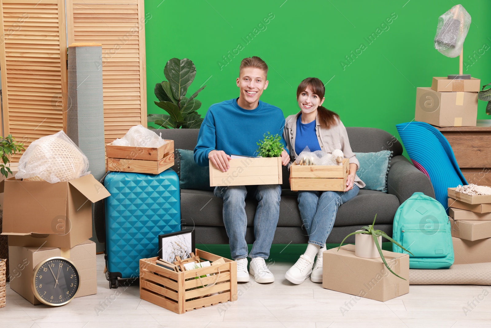 Photo of Happy couple with different stuff in new apartment. Housewarming party