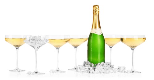 Photo of Bottle and glasses of champagne with ice cubes isolated on white