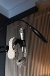 Photo of Stand with microphone, headphones and pop filter indoors, low angle view. Sound recording and reinforcement