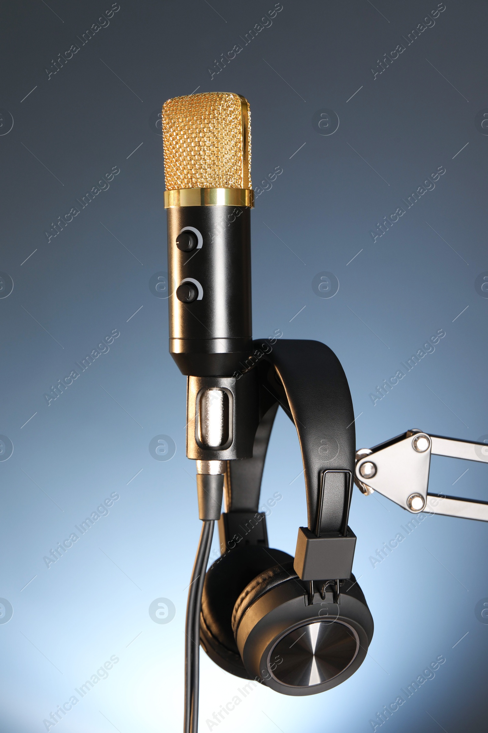 Photo of Stand with microphone and headphones on dark background. Sound recording and reinforcement