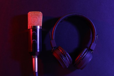 Photo of Microphone and headphones on color background, flat lay. Sound recording and reinforcement