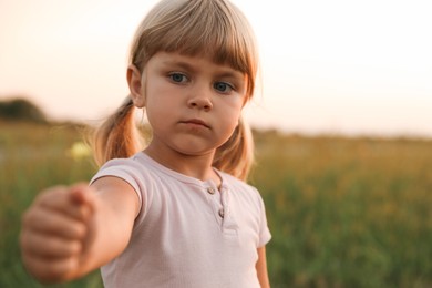 Photo of Cute little girl with flower at meadow. Child enjoying beautiful nature