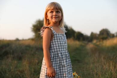 Photo of Cute little girl at meadow. Child enjoying beautiful nature