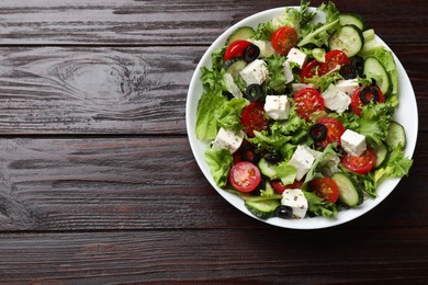 Photo of Delicious salad with feta cheese on wooden table, top view. Space for text