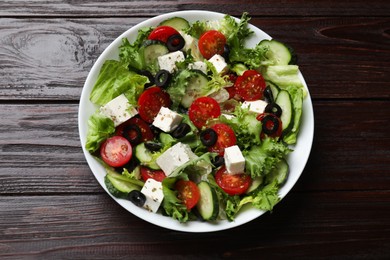 Photo of Delicious salad with feta cheese on wooden table, top view