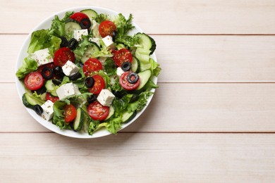 Photo of Delicious salad with feta cheese on white wooden table, top view. Space for text