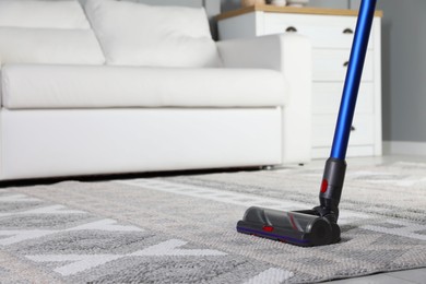 Photo of Cleaning with wireless vacuum cleaner at home, closeup. Space for text