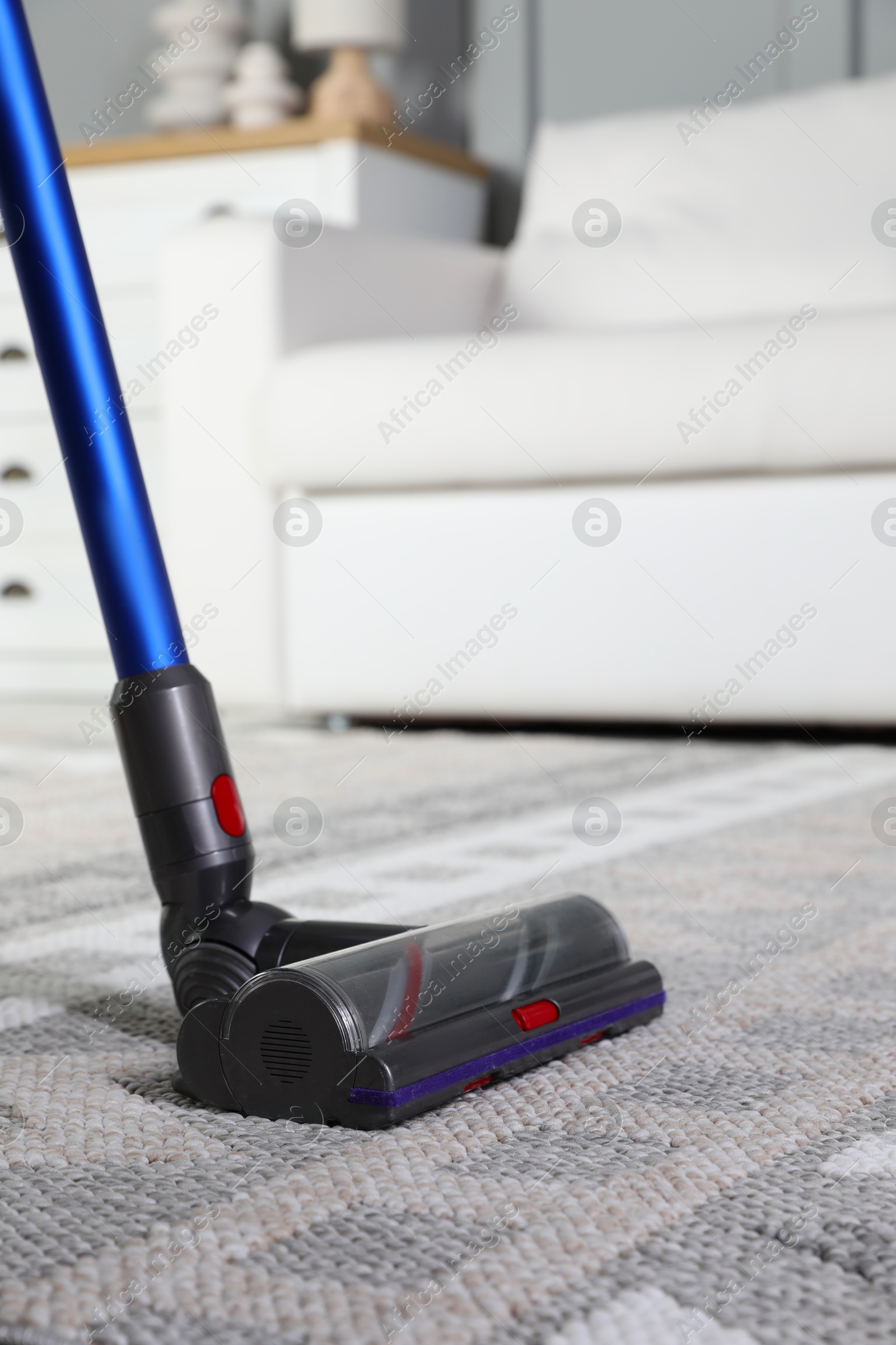 Photo of Cleaning with wireless vacuum cleaner at home, closeup