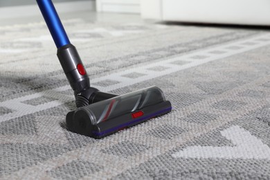 Photo of Cleaning with wireless vacuum cleaner at home, closeup. Space for text