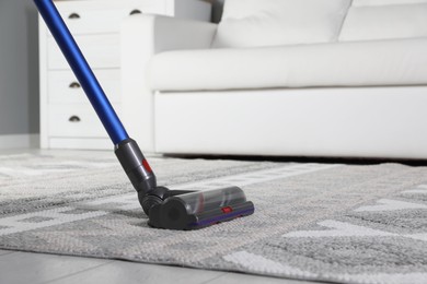 Photo of Cleaning with wireless vacuum cleaner at home, closeup. Space for text