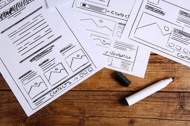 Photo of Developing UI design. Sketches of website wireframes and felt pen on wooden table, top view