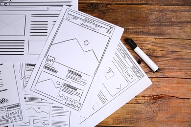 Photo of Developing UI design. Sketches of website wireframes and felt pen on wooden table, top view