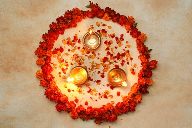 Photo of Diwali celebration. Diya lamps and beautiful flowers on light background, top view