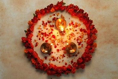 Photo of Diwali celebration. Diya lamps and beautiful flowers on light background, top view