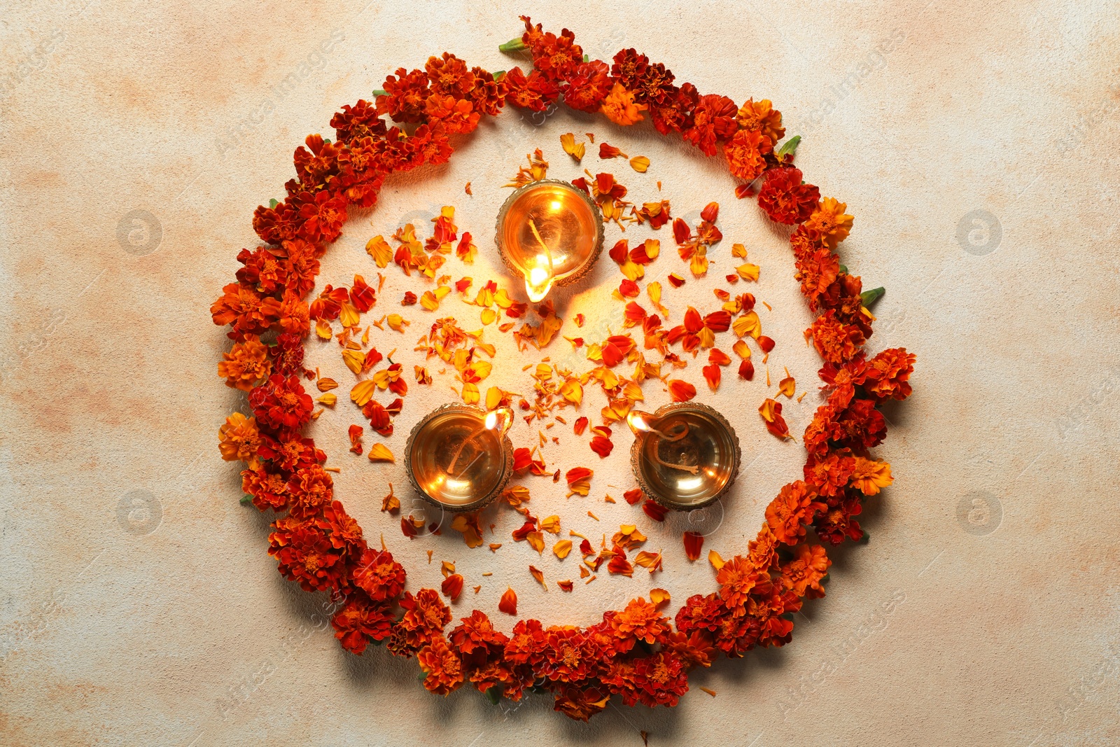 Photo of Diwali celebration. Diya lamps and beautiful flowers on light background, top view