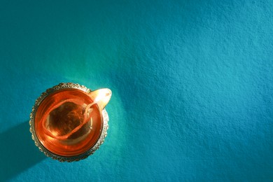 Photo of Diwali celebration. Diya lamp on teal background, top view. Space for text