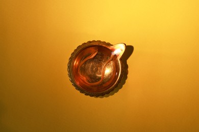 Photo of Diwali celebration. Diya lamp on orange background, top view