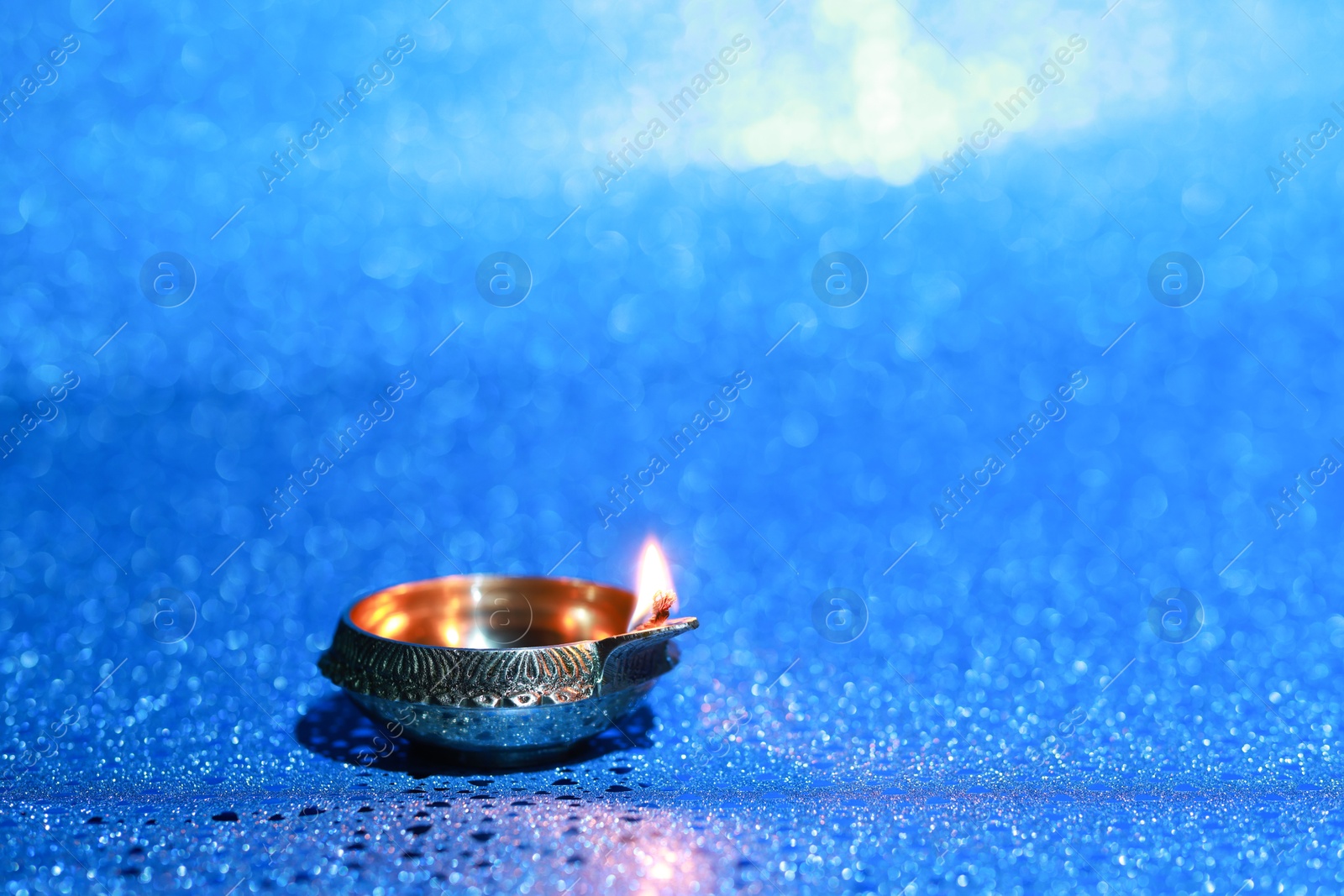 Photo of Diwali celebration. Diya lamp on blue background. Space for text