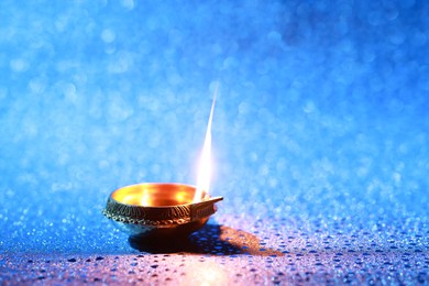 Photo of Diwali celebration. Diya lamp on blue background. Space for text