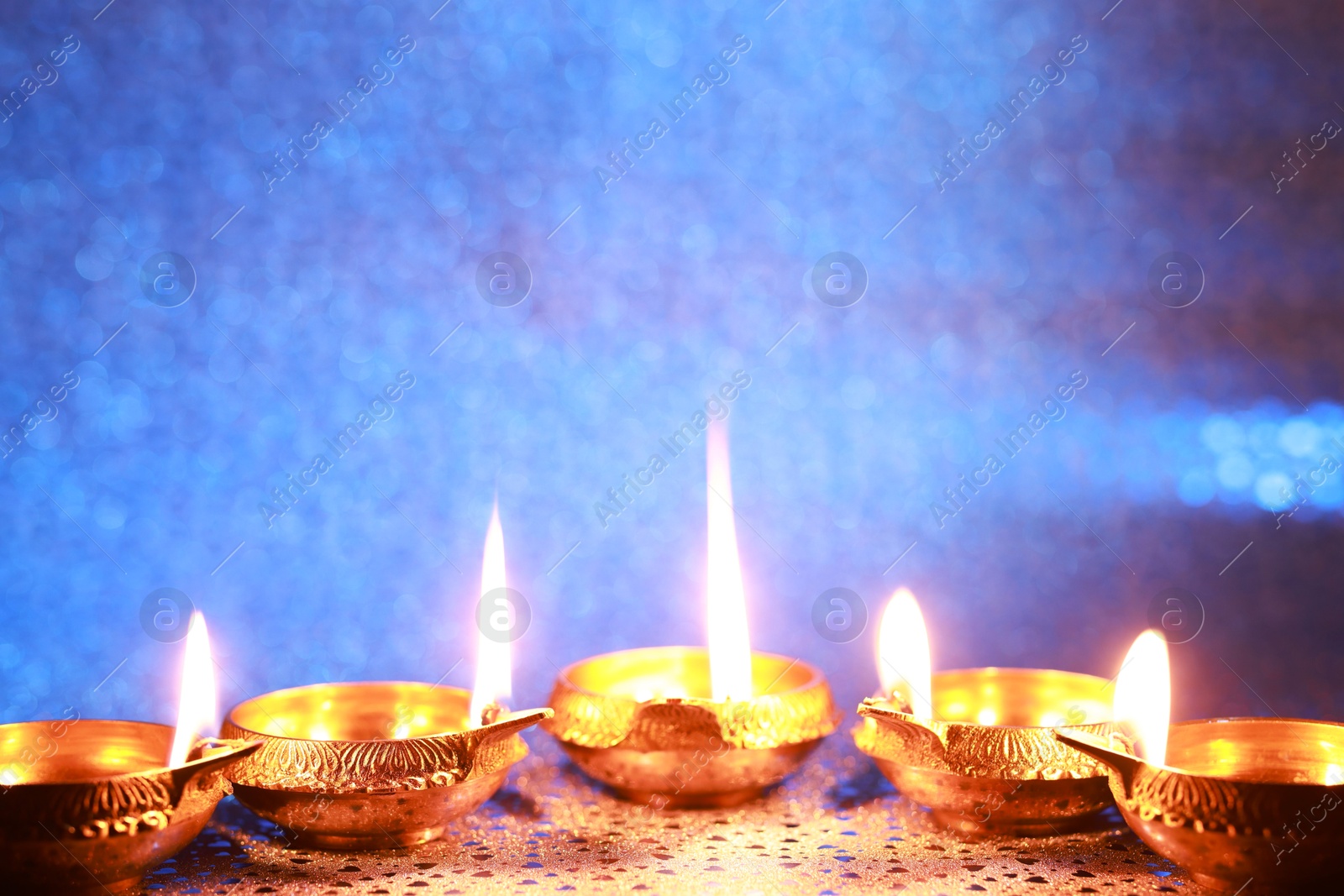 Photo of Diwali celebration. Diya lamps on color background. Space for text