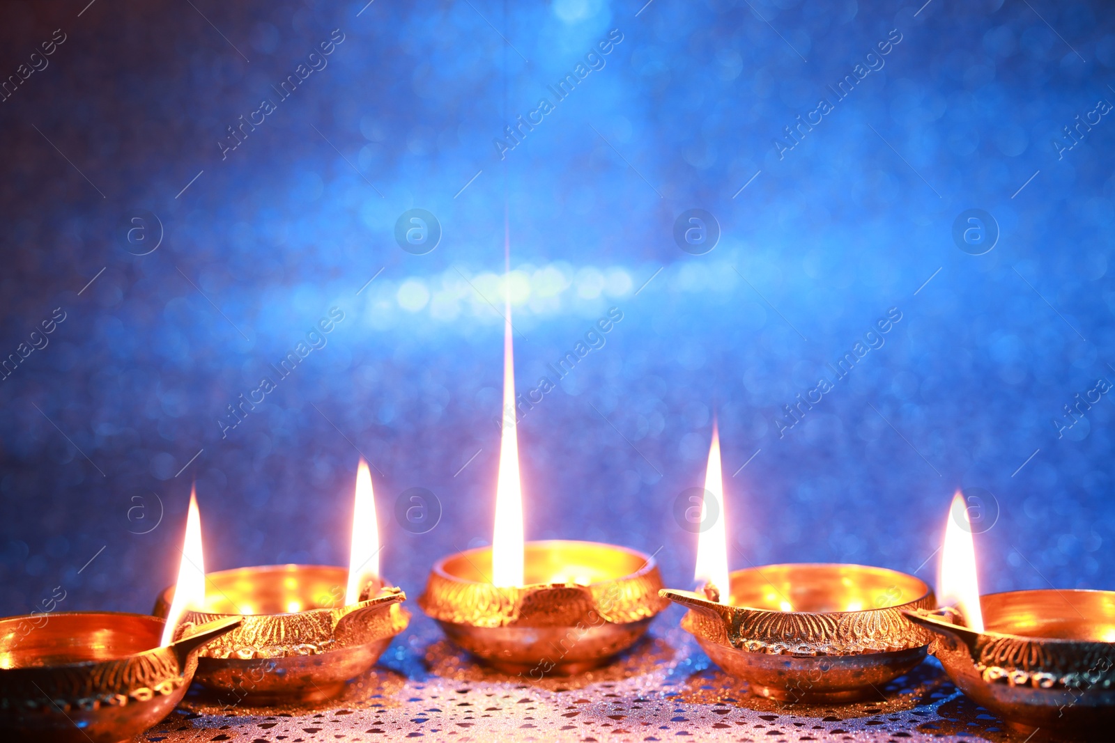 Photo of Diwali celebration. Diya lamps on color background. Space for text