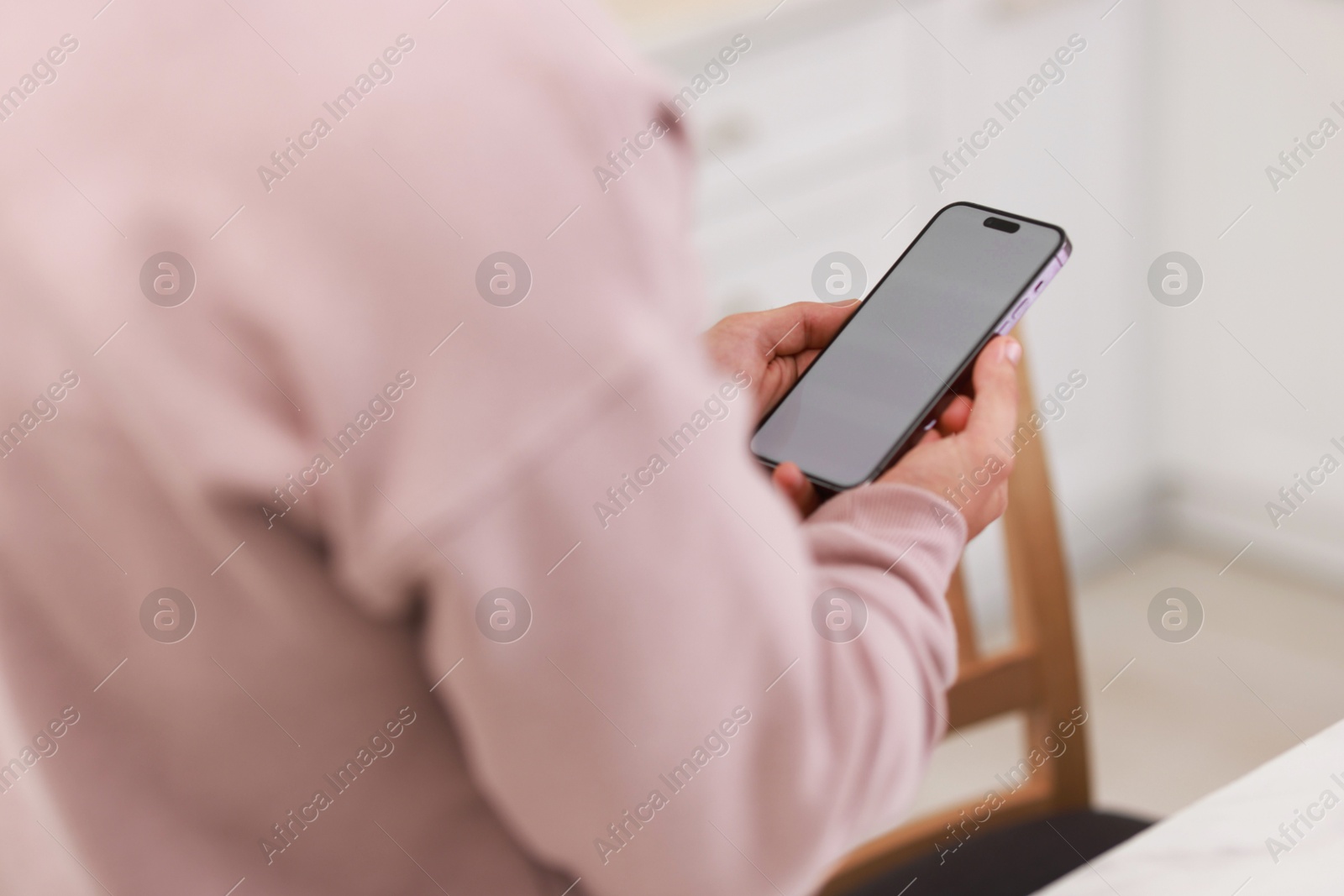 Photo of Man using modern smartphone indoors, closeup view